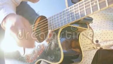 男人手弹吉他。 吉他手触摸吉他弦。 近距离射击。